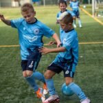 Kids in customised football kit, playing football