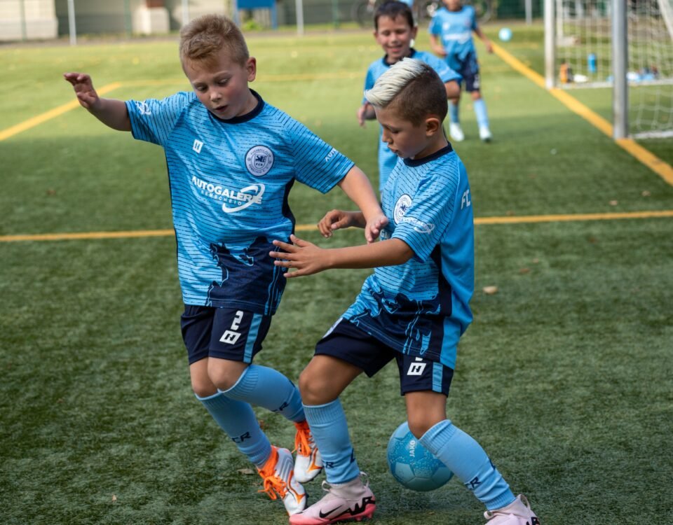 Kids in customised football kit, playing football